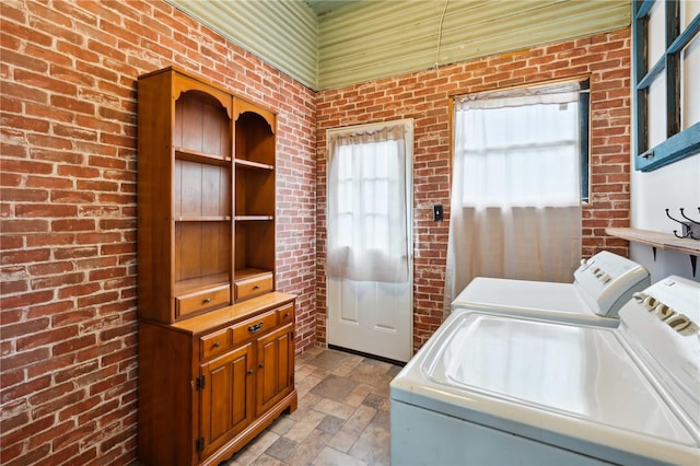 263 NE 1st St, Webster, FL 33597 - laundry room featuring washing machine and clothes dryer, brick wall, and light stone finish floors