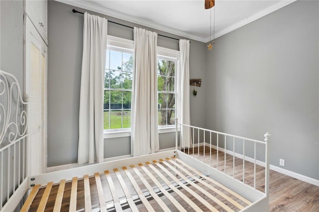 263 NE 1st St, Webster, FL 33597 - unfurnished bedroom featuring wood finished floors, crown molding, and a ceiling fan