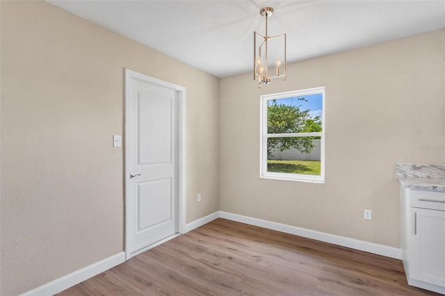 4 Kristin Ln, Eustis, FL 32726 - unfurnished dining area featuring a chandelier, baseboards, and wood finished floors