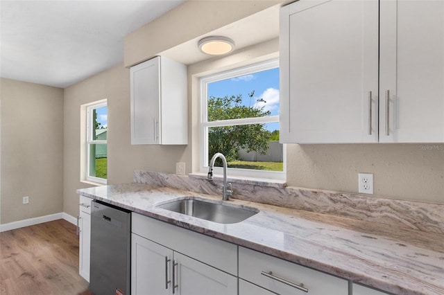 4 Kristin Ln, Eustis, FL 32726 - kitchen with dishwasher, a sink, white cabinetry, light wood finished floors, and baseboards