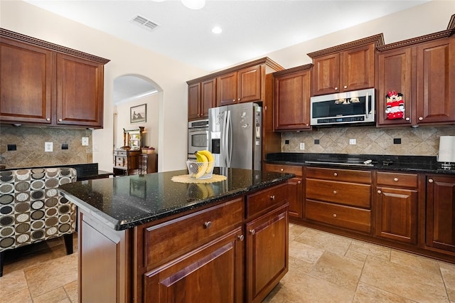 5144 Rishley Run Way, Mount Dora, FL 32757 - kitchen featuring appliances with stainless steel finishes, arched walkways, decorative backsplash, dark stone counters, and recessed lighting