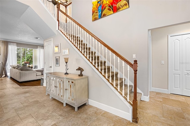 5144 Rishley Run Way, Mount Dora, FL 32757 - stairway with baseboards, stone tile floors, and a towering ceiling
