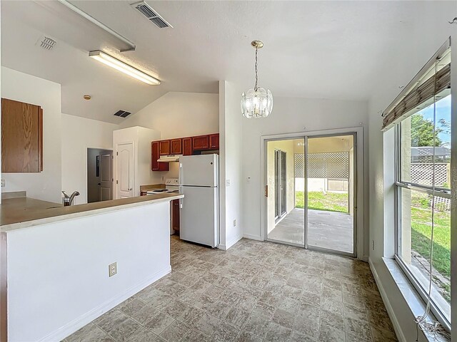 439 Gentle Breeze Dr, Minneola, FL 34715 - kitchen featuring white appliances, vaulted ceiling, a chandelier, healthy amount of natural light, and baseboards