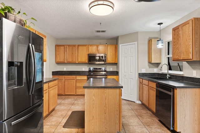 800 Daybreak Dr, Fruitland Park, FL 34731 - kitchen featuring stainless steel appliances, dark countertops, a kitchen island, a textured ceiling, and light tile patterned floors