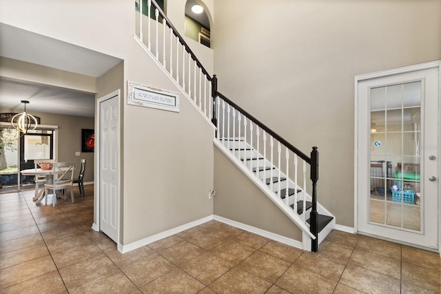 800 Daybreak Dr, Fruitland Park, FL 34731 - stairs with tile patterned floors, a chandelier, and a high ceiling