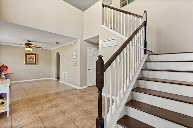 800 Daybreak Dr, Fruitland Park, FL 34731 - staircase featuring a ceiling fan, arched walkways, tile patterned flooring, crown molding, and a towering ceiling