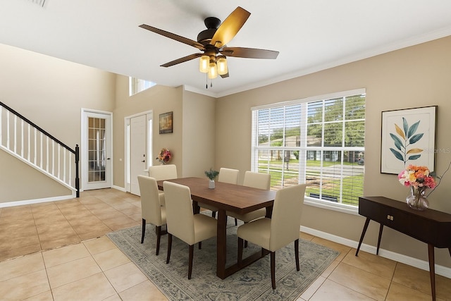 800 Daybreak Dr, Fruitland Park, FL 34731 - dining area with light tile patterned floors, stairway, ornamental molding, and ceiling fan