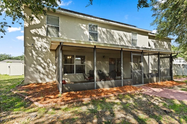 800 Daybreak Dr, Fruitland Park, FL 34731 - rear view of house with a sunroom, a gate, and stucco siding