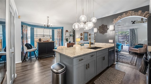 1130 Woodsong Way, Clermont, FL 34714 - kitchen featuring a sink, a chandelier, wood finished floors, light stone countertops, and pendant lighting
