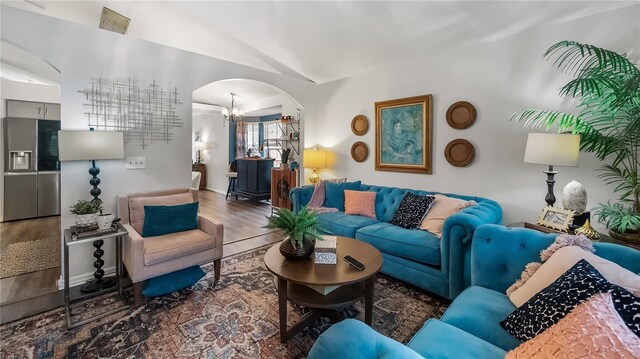 1130 Woodsong Way, Clermont, FL 34714 - living area featuring arched walkways, a chandelier, wood finished floors, and vaulted ceiling