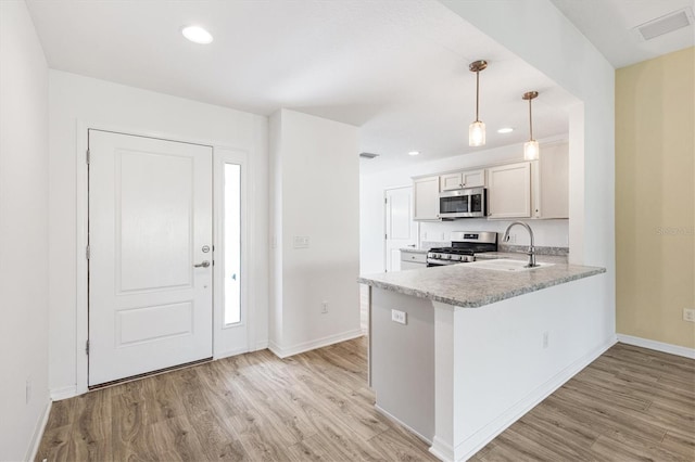 4157 Tiedemann Loop, The Villages, FL 32163 - kitchen featuring appliances with stainless steel finishes, light wood finished floors, light countertops, a sink, and recessed lighting
