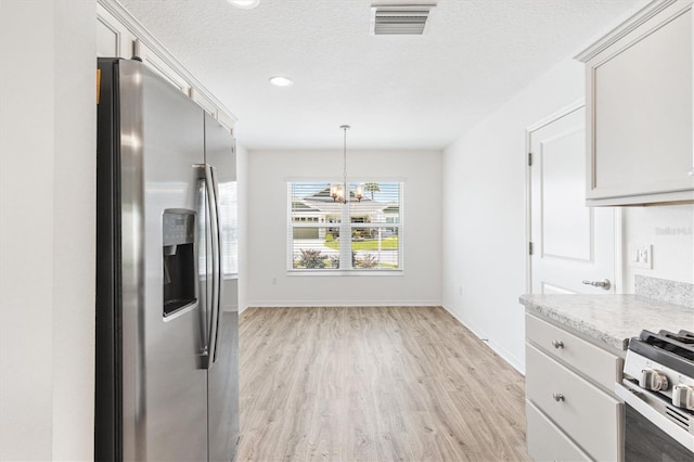 4157 Tiedemann Loop, The Villages, FL 32163 - kitchen featuring stainless steel refrigerator with ice dispenser, a chandelier, light wood-style floors, baseboards, and a textured ceiling
