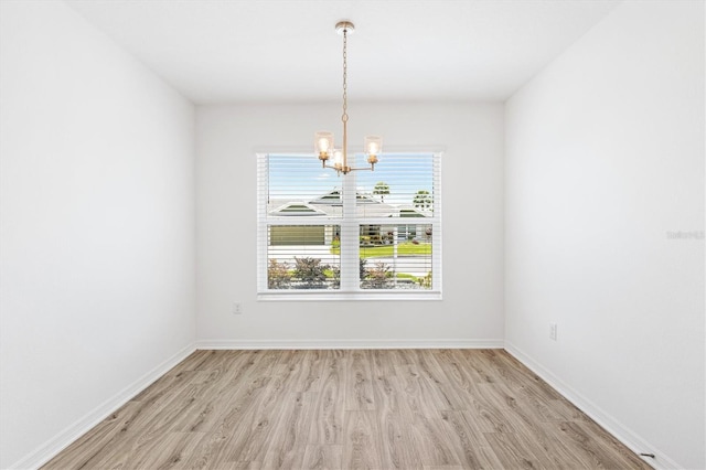 4157 Tiedemann Loop, The Villages, FL 32163 - empty room featuring a chandelier, light wood-style flooring, and baseboards