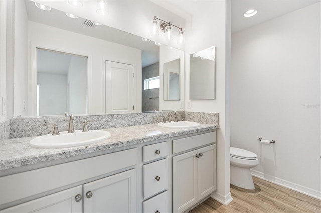 4157 Tiedemann Loop, The Villages, FL 32163 - bathroom with double vanity, toilet, wood finished floors, and baseboards