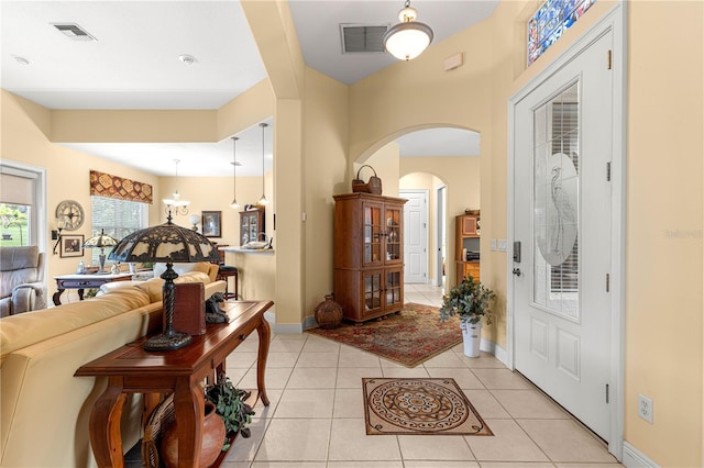 39145 Treeline Dr, Lady Lake, FL 32159 - entryway featuring arched walkways, baseboards, and light tile patterned floors