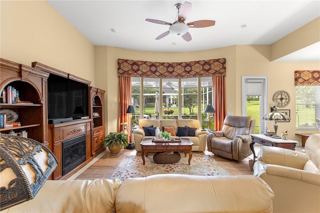 39145 Treeline Dr, Lady Lake, FL 32159 - living area featuring ceiling fan, light wood-style flooring, and a glass covered fireplace