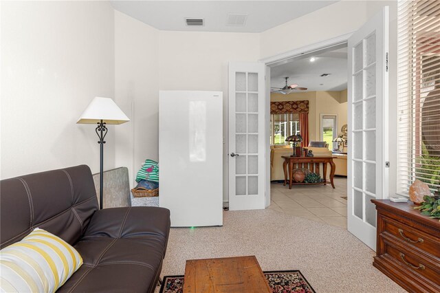 39145 Treeline Dr, Lady Lake, FL 32159 - carpeted living room featuring french doors, a ceiling fan, and tile patterned floors