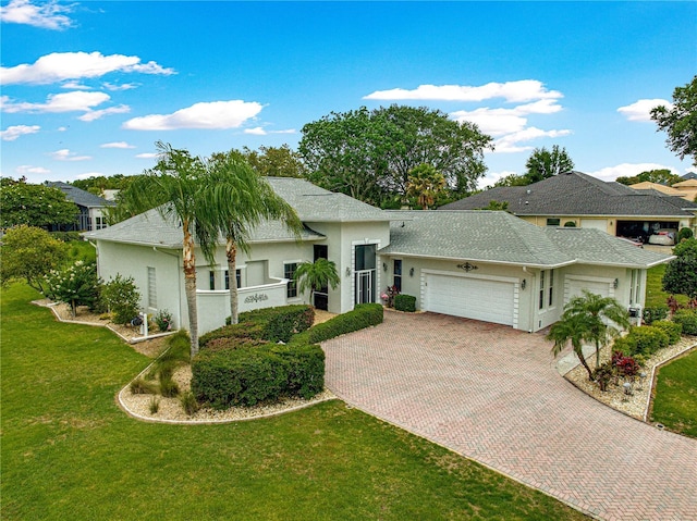 39145 Treeline Dr, Lady Lake, FL 32159 - view of front of home featuring a garage, decorative driveway, stucco siding, and a front yard