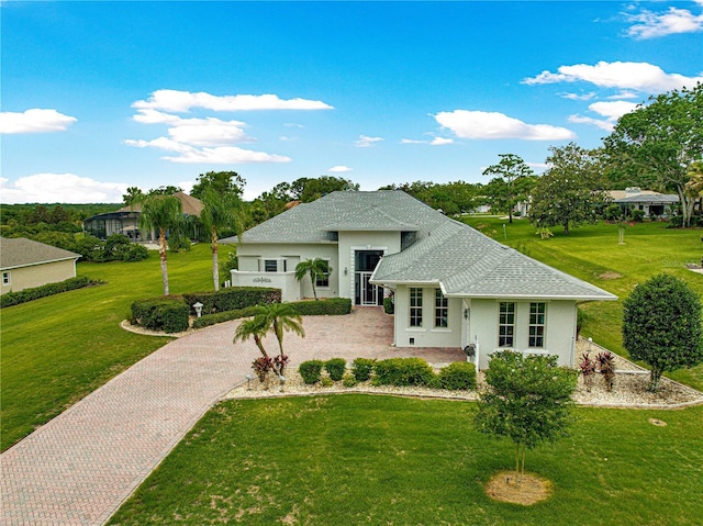 39145 Treeline Dr, Lady Lake, FL 32159 - view of front of home featuring stucco siding, a front lawn, a shingled roof, and decorative driveway