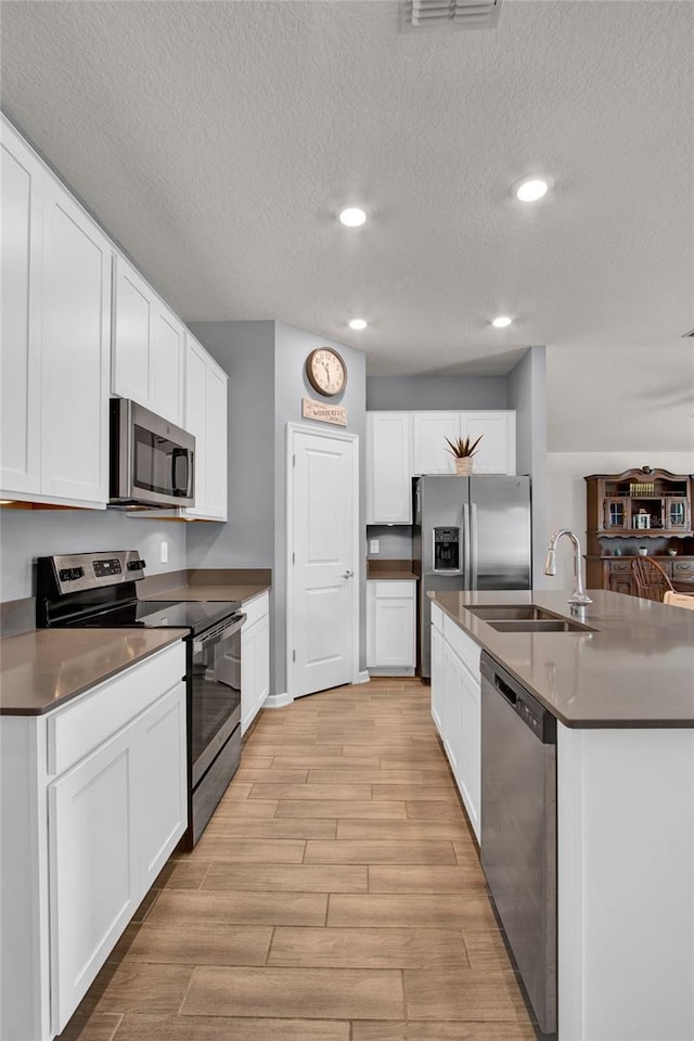 733 Citrus Reserve Blvd, Davenport, FL 33837 - kitchen featuring appliances with stainless steel finishes, a sink, a textured ceiling, light wood finished floors, and recessed lighting