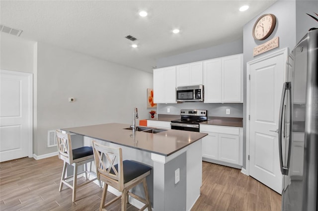 733 Citrus Reserve Blvd, Davenport, FL 33837 - kitchen featuring stainless steel appliances, a sink, light wood finished floors, an island with sink, and recessed lighting