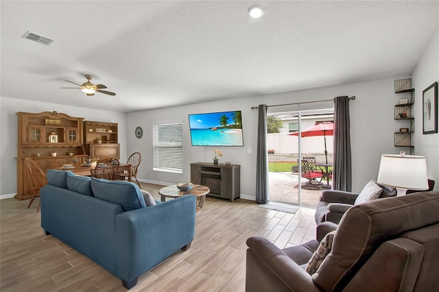 733 Citrus Reserve Blvd, Davenport, FL 33837 - living area with light wood-style floors, baseboards, a ceiling fan, and a textured ceiling