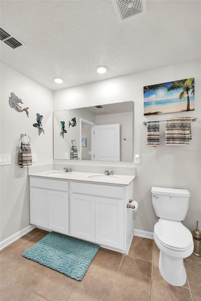 733 Citrus Reserve Blvd, Davenport, FL 33837 - bathroom with double vanity, tile patterned floors, baseboards, a textured ceiling, and toilet