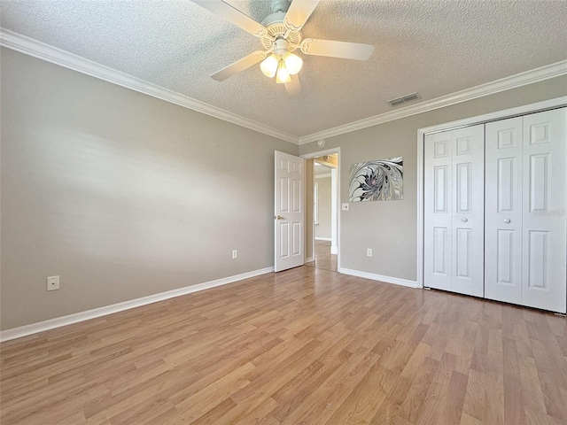 3237 Atwell Ave, The Villages, FL 32162 - unfurnished bedroom featuring a textured ceiling, light wood finished floors, crown molding, baseboards, and a closet