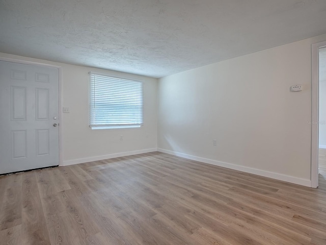 59 S Columbus St, Beverly Hills, FL 34465 - unfurnished room with light wood-type flooring, baseboards, and a textured ceiling