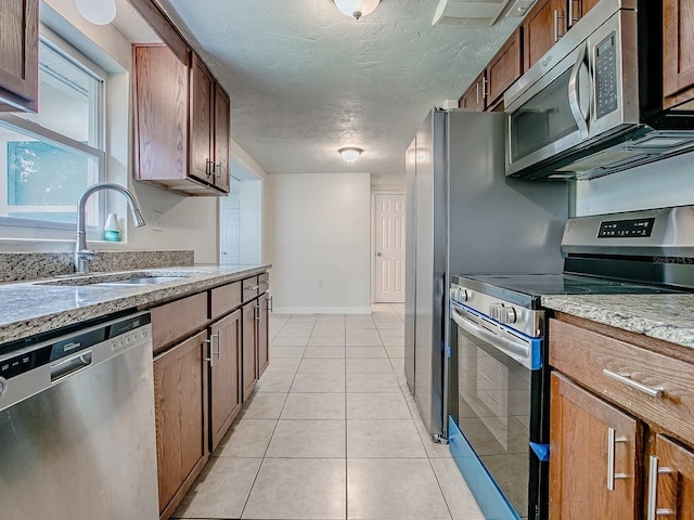 59 S Columbus St, Beverly Hills, FL 34465 - kitchen with stainless steel appliances, a sink, light tile patterned flooring, baseboards, and a textured ceiling