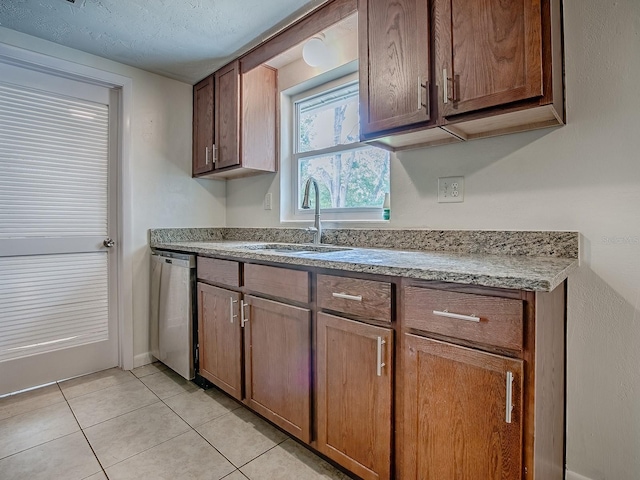 59 S Columbus St, Beverly Hills, FL 34465 - kitchen featuring stainless steel dishwasher, a sink, light tile patterned floors, light stone countertops, and baseboards