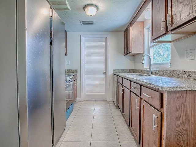 59 S Columbus St, Beverly Hills, FL 34465 - kitchen featuring a sink, appliances with stainless steel finishes, light tile patterned floors, light stone countertops, and baseboards