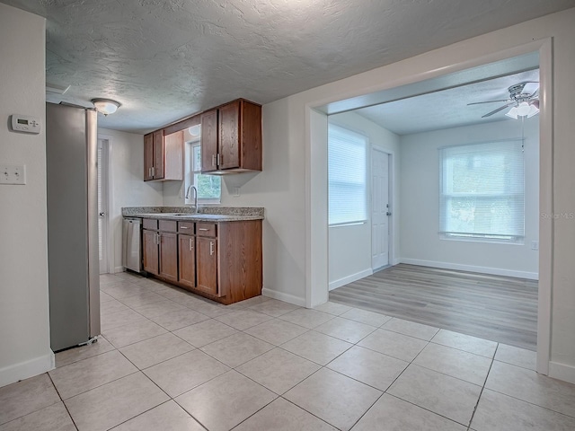 59 S Columbus St, Beverly Hills, FL 34465 - kitchen featuring stainless steel dishwasher, a sink, light tile patterned flooring, baseboards, and a ceiling fan