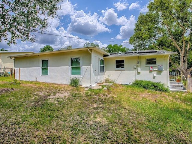 59 S Columbus St, Beverly Hills, FL 34465 - rear view of property featuring stucco siding and solar panels