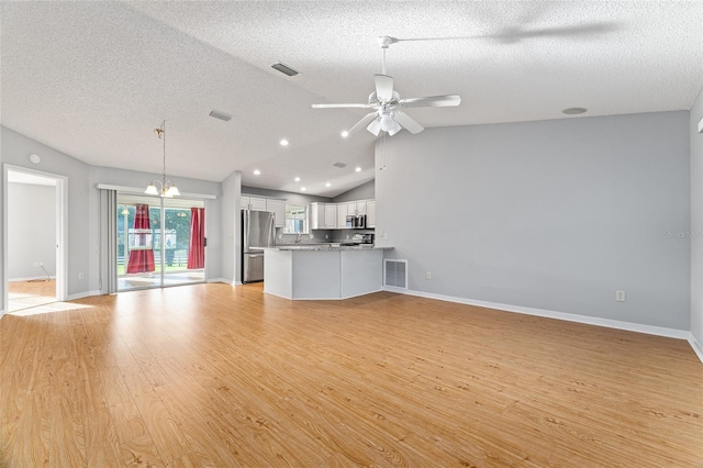 2557 Privada Dr, The Villages, FL 32162 - unfurnished living room featuring light wood-style flooring, vaulted ceiling, ceiling fan, a textured ceiling, and baseboards