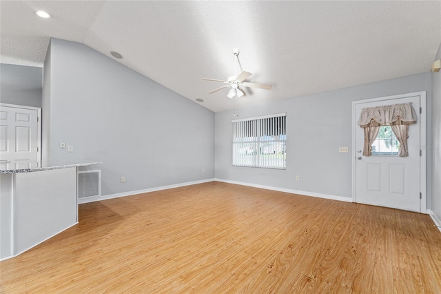 2557 Privada Dr, The Villages, FL 32162 - unfurnished living room with ceiling fan, lofted ceiling, light wood-style floors, and baseboards