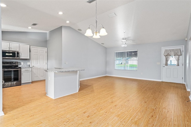 2557 Privada Dr, The Villages, FL 32162 - kitchen with stainless steel appliances, lofted ceiling, a chandelier, light wood-style flooring, and hanging light fixtures