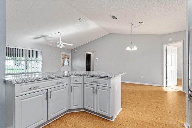 2557 Privada Dr, The Villages, FL 32162 - kitchen with a chandelier, a ceiling fan, light wood-style floors, lofted ceiling, and a textured ceiling