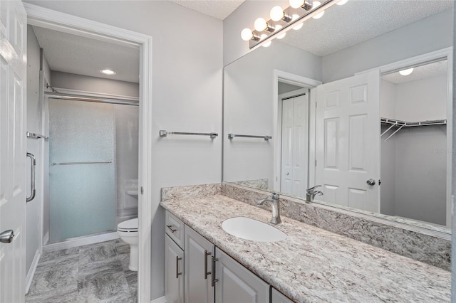 2557 Privada Dr, The Villages, FL 32162 - bathroom with a textured ceiling, vanity, a shower stall, toilet, and baseboards