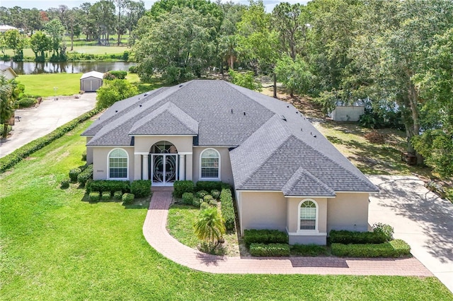 29152 David Ct, Tavares, FL 32778 - view of front facade with a water view, stucco siding, roof with shingles, and a front lawn