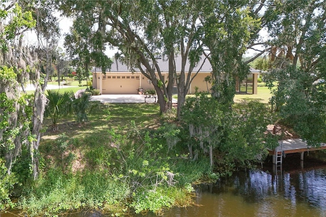 29152 David Ct, Tavares, FL 32778 - view of grassy yard featuring a water view, a garage, and driveway