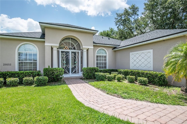 29152 David Ct, Tavares, FL 32778 - entrance to property featuring a yard, stucco siding, and roof with shingles