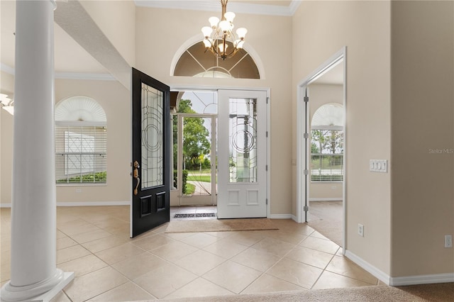 29152 David Ct, Tavares, FL 32778 - entrance foyer featuring a chandelier, light tile patterned floors, crown molding, decorative columns, and a towering ceiling