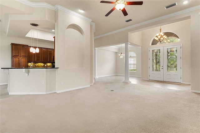 29152 David Ct, Tavares, FL 32778 - unfurnished living room with a chandelier, a ceiling fan, decorative columns, light carpet, and french doors