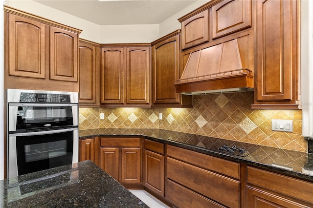 29152 David Ct, Tavares, FL 32778 - kitchen with stainless steel double oven, black electric cooktop, premium range hood, dark stone counters, and backsplash