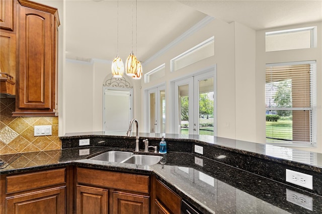 29152 David Ct, Tavares, FL 32778 - kitchen featuring dark stone counters, a chandelier, tasteful backsplash, french doors, and crown molding