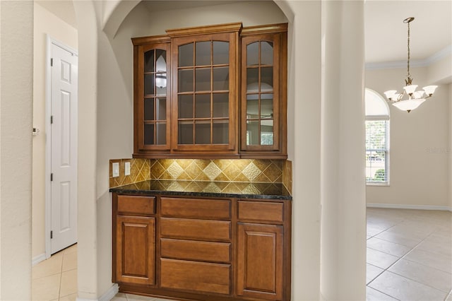 29152 David Ct, Tavares, FL 32778 - bar area featuring arched walkways, light tile patterned floors, backsplash, ornamental molding, and a chandelier