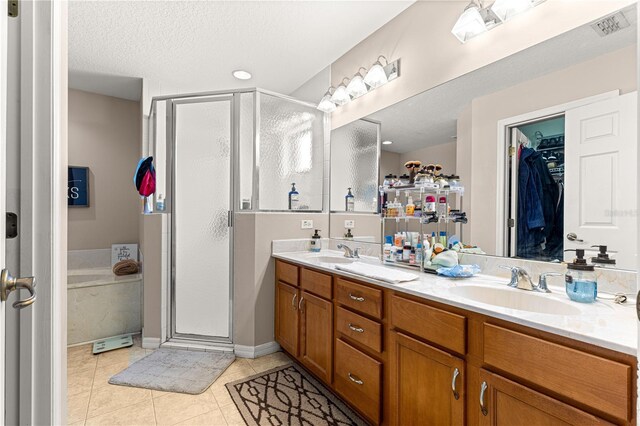 70 Locust Pass Run, Ocala, FL 34472 - bathroom featuring a stall shower, double vanity, tile patterned floors, a spacious closet, and a textured ceiling