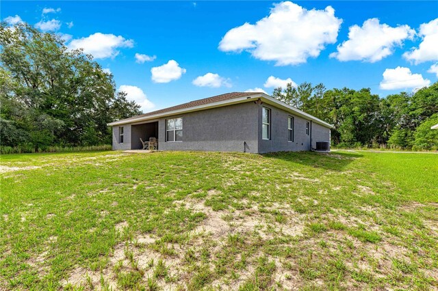 70 Locust Pass Run, Ocala, FL 34472 - rear view of house with stucco siding and a yard