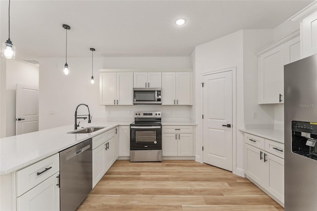 1809 W Linden Dr, Citrus Springs, FL 34434 - kitchen with stainless steel appliances, a peninsula, white cabinetry, light wood-style flooring, and recessed lighting